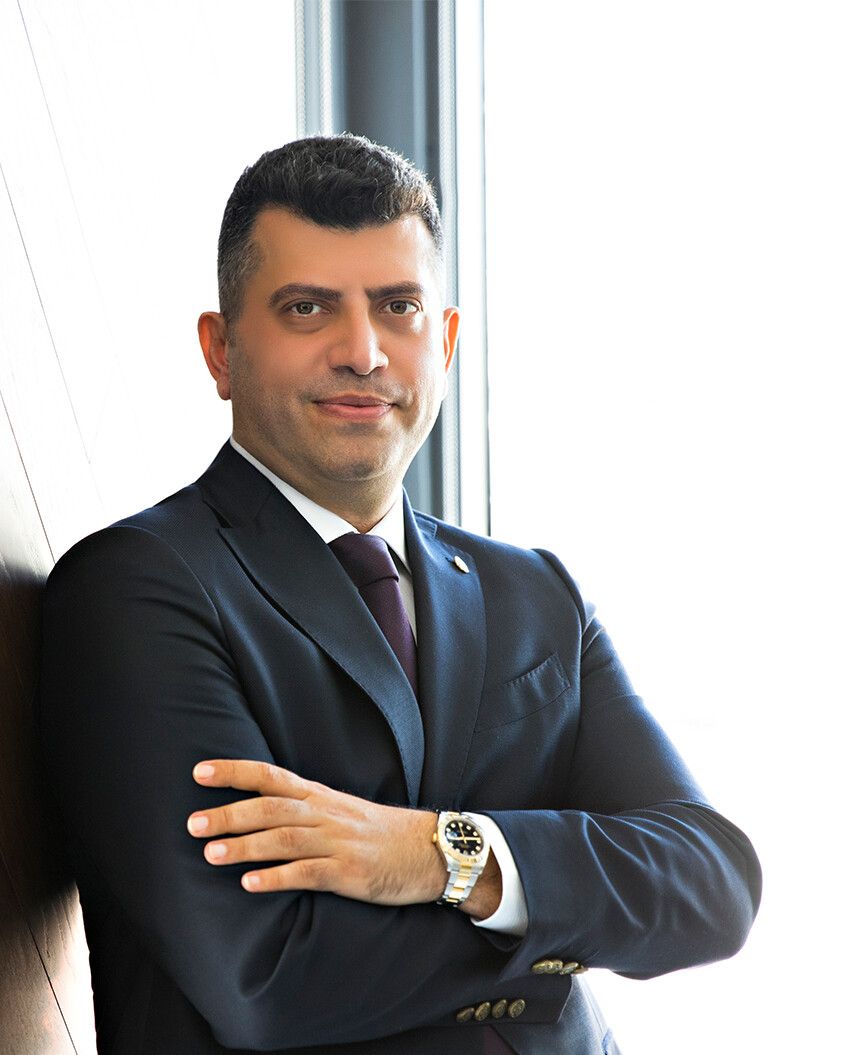 Op. Dr. Cenk Teker, ear, nose and throat surgeon, standing by a window in a navy suit
